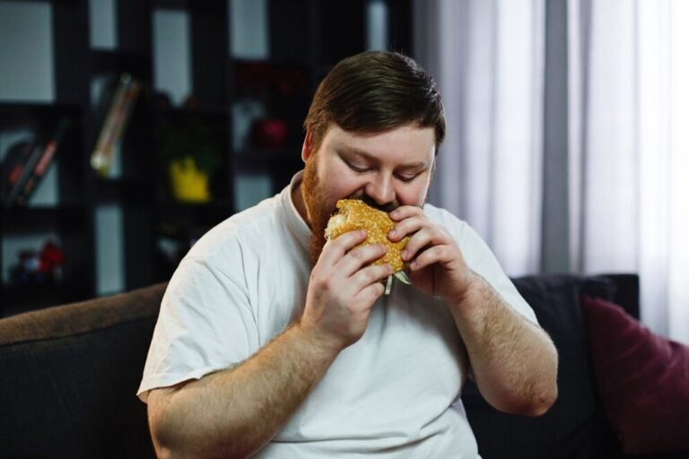 a overweight or obese-fat-man-eats-burger